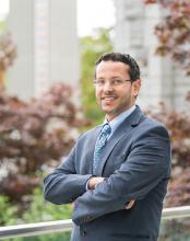 Muhammad Abdul-Mageed stands smiling with his arms crossed in a confident stance