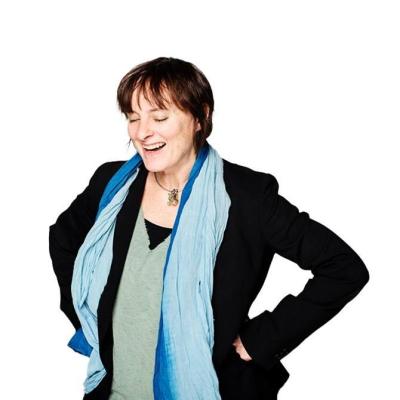 Dr. Rebecca Todd stands with her hands on hips, laughing